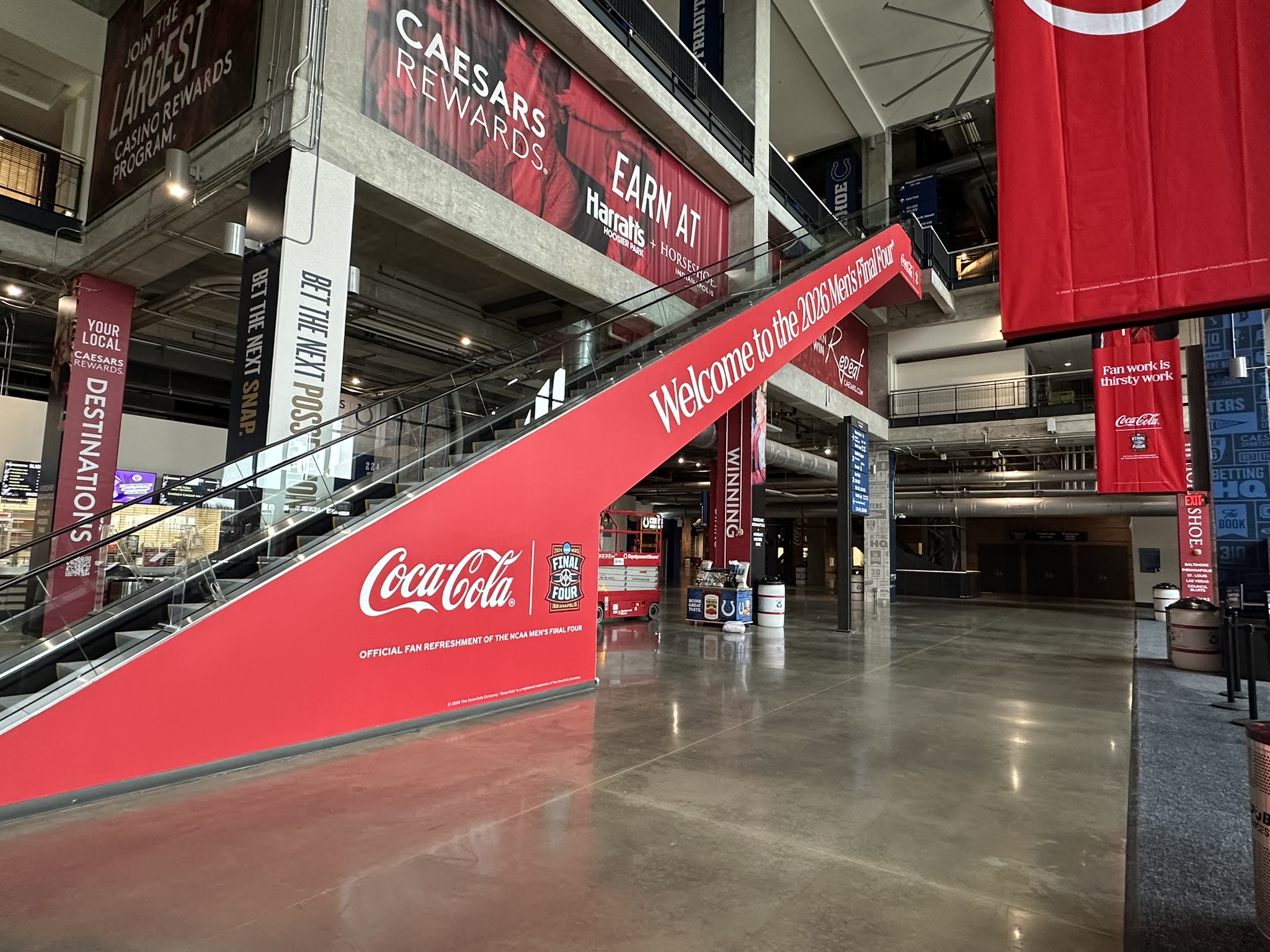 Red Final Four and Coca-Cola graphics covering the side of a stadium escalator