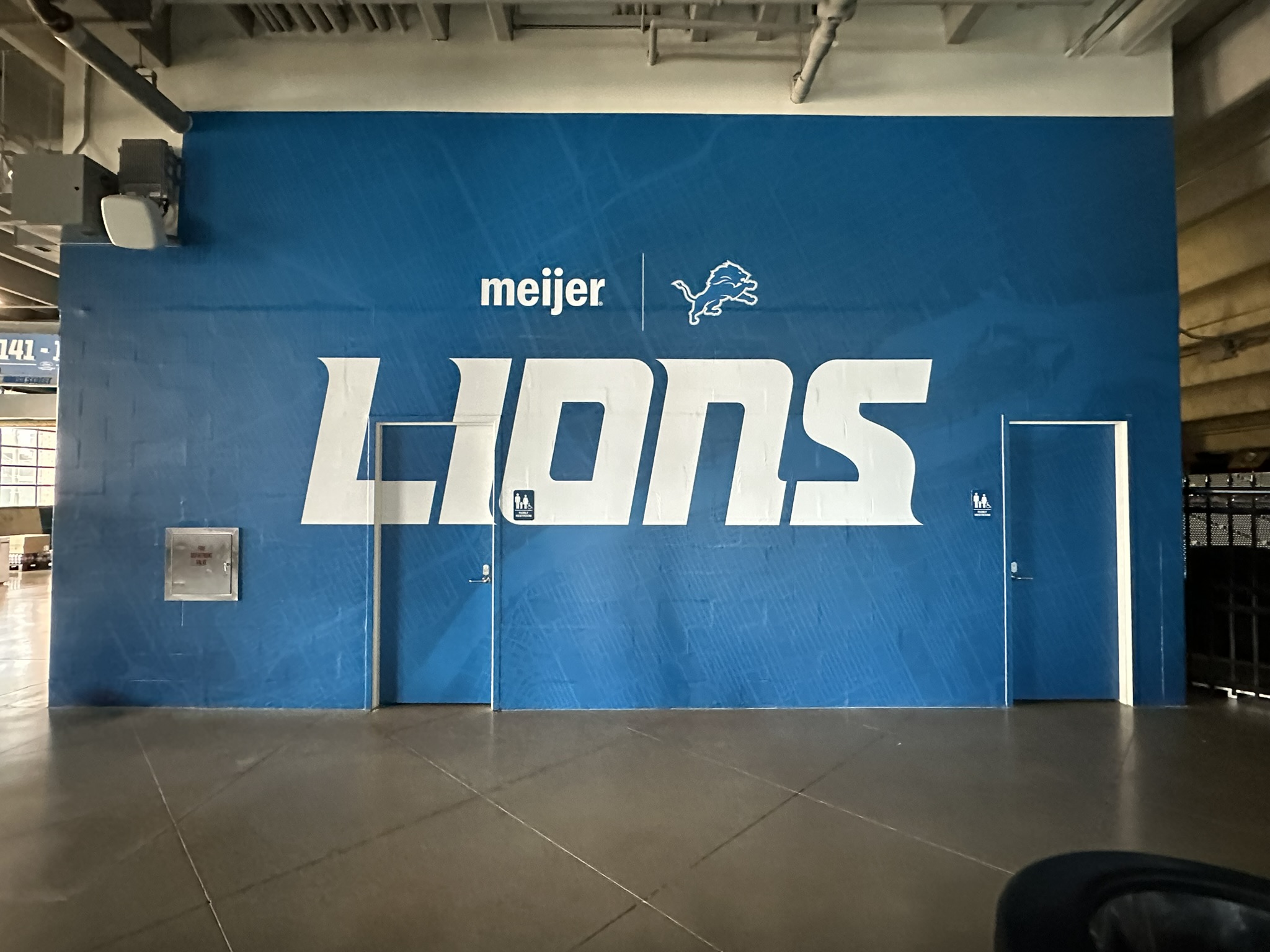 Blue Detroit Lions and Meijer wall wrap extending across a tall wall and two doors