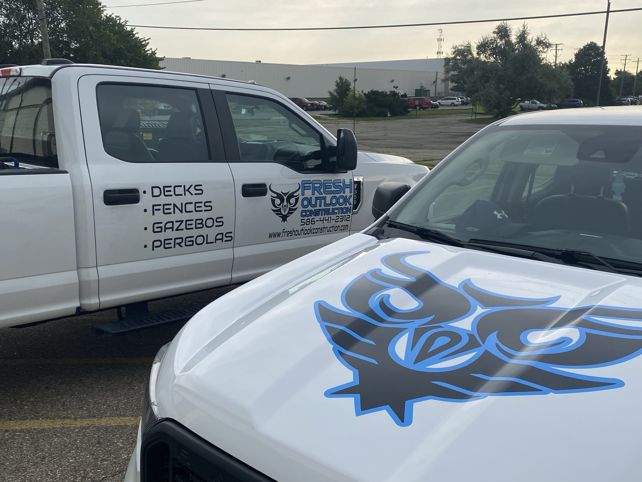 Fresh Outlook Construction fleet vehicles with matching blue and black graphics
