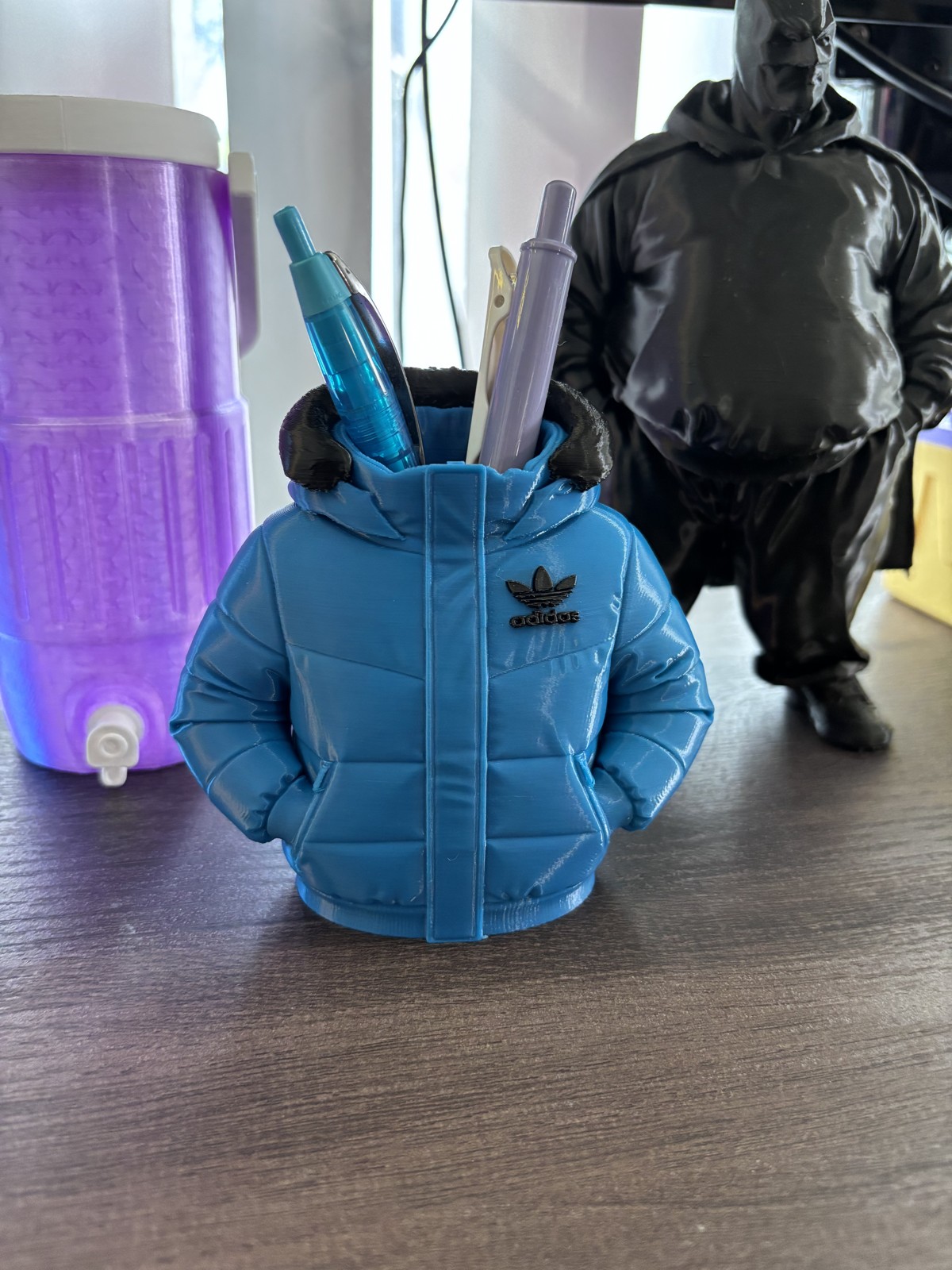 Blue puffer-jacket-shaped pen holder holding pens