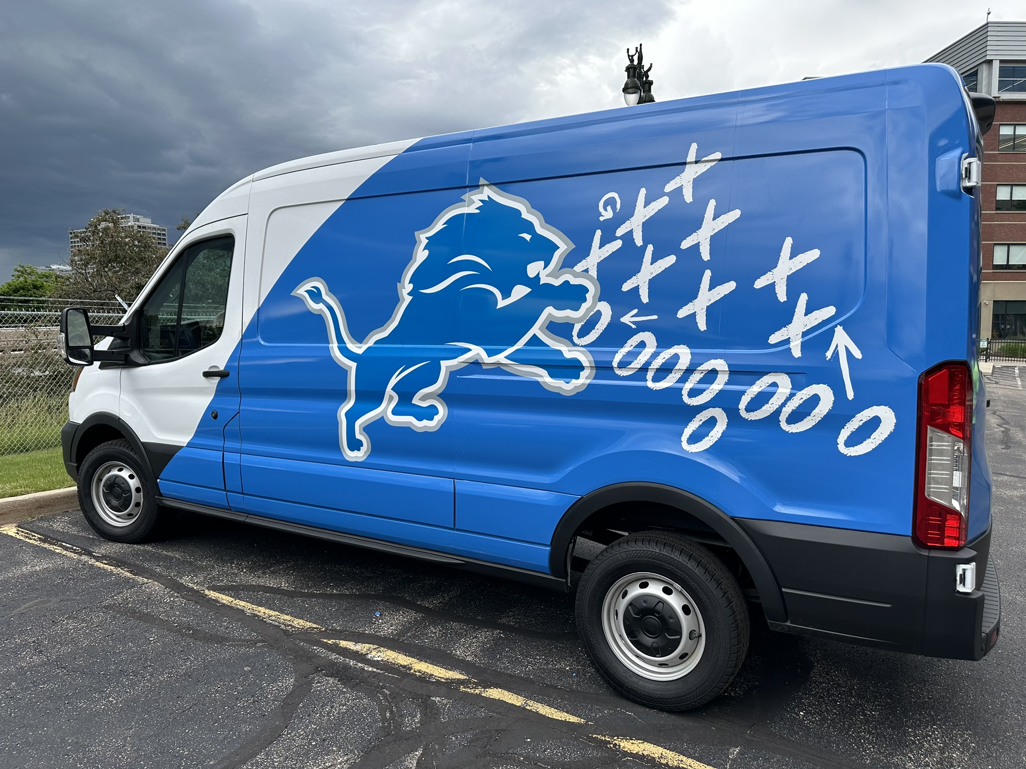 Blue and white Detroit Lions graphics installed on a Ford Transit van