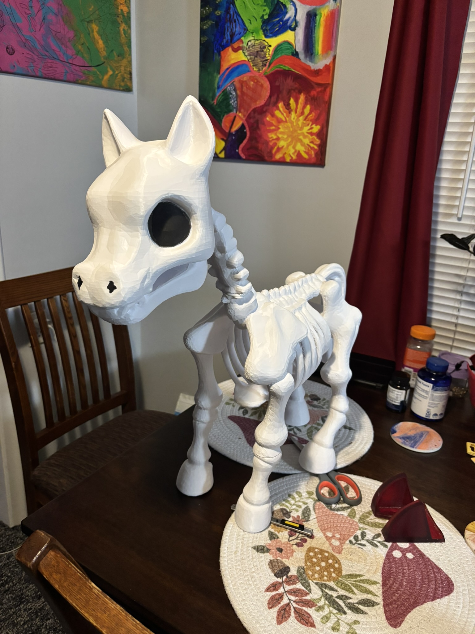 White horse-like skeleton model with detailed skull, ribs, and legs on a table