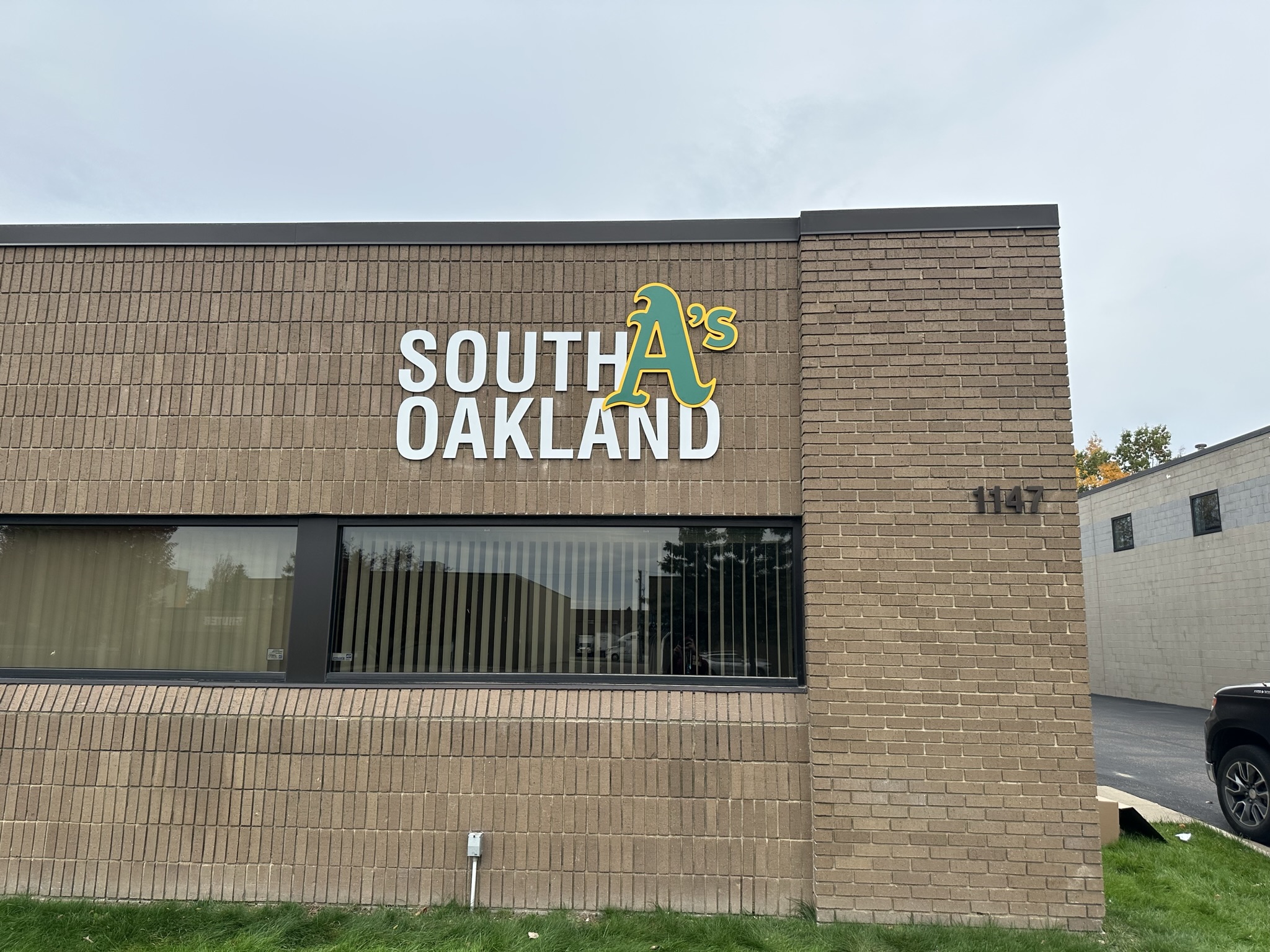 South Oakland exterior lettering and green and yellow logo on a brick building